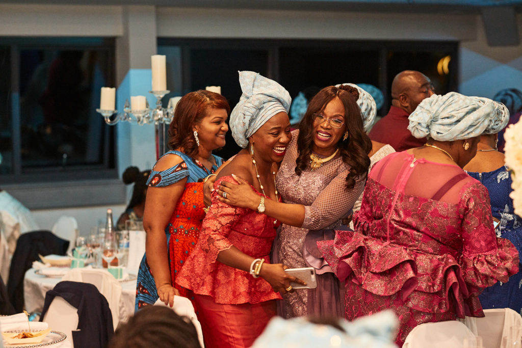 Guests in matching head ties hugging on the dance floor