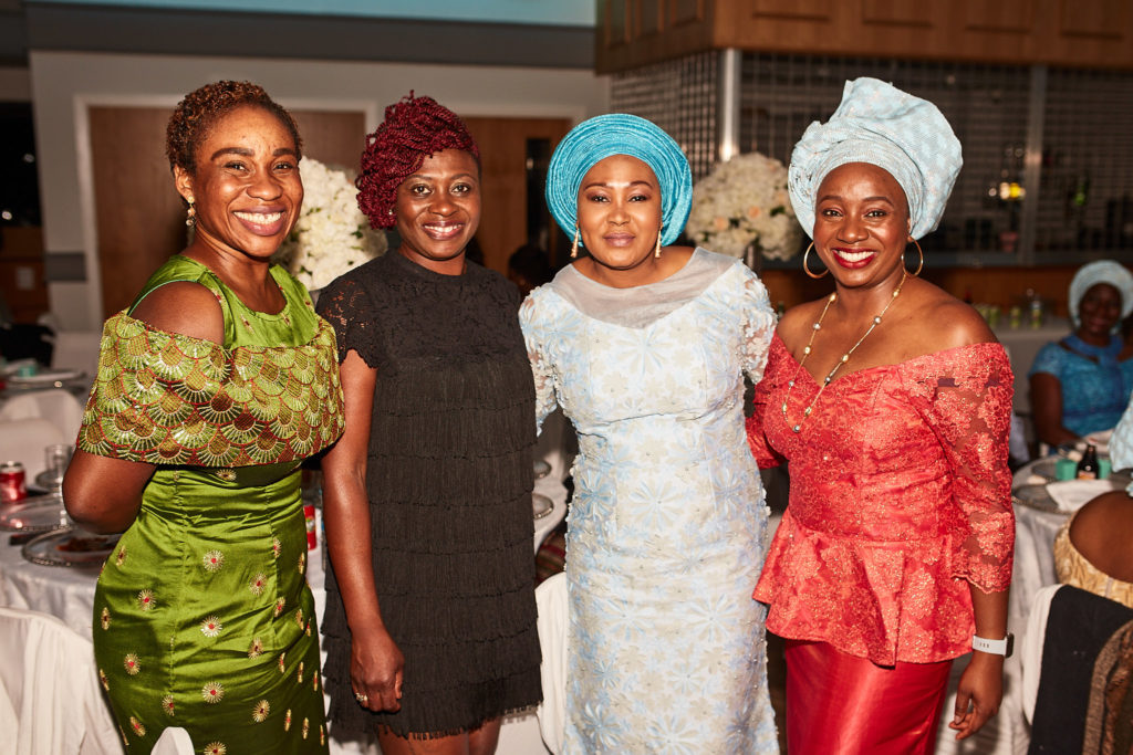 Four guests posing together at the party