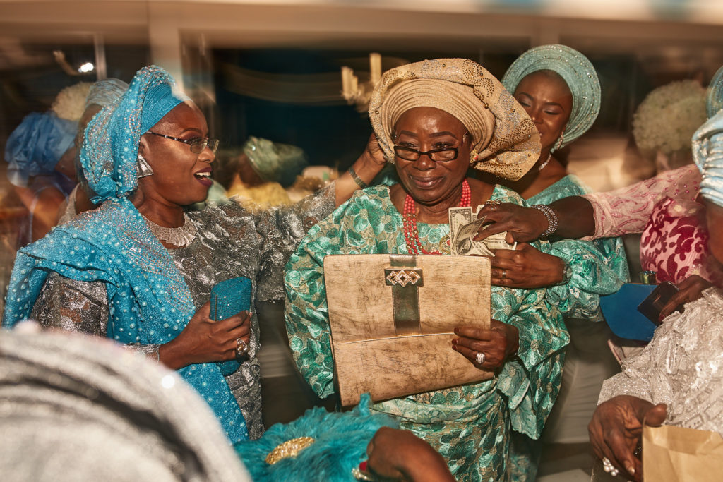 Guest in a green lace outfit laughing among friends on the dance floor