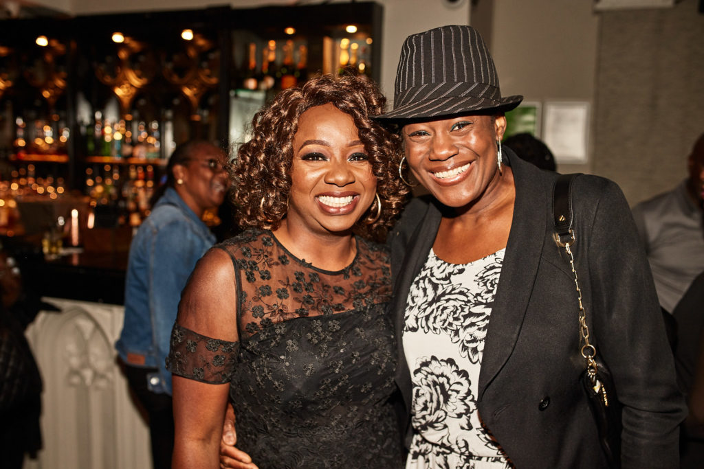 Birthday host with a friend in a trilby hat