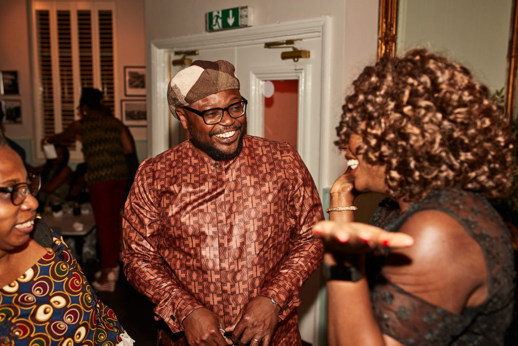 Guest in a red patterned shirt laughing with the birthday host