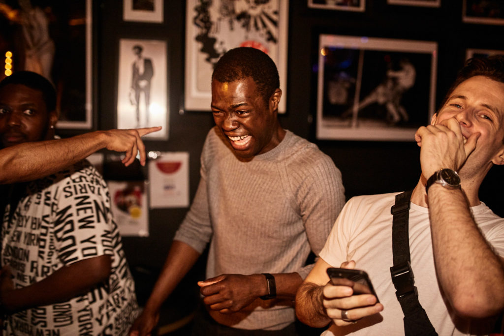 Three guests laughing together at the charity club night