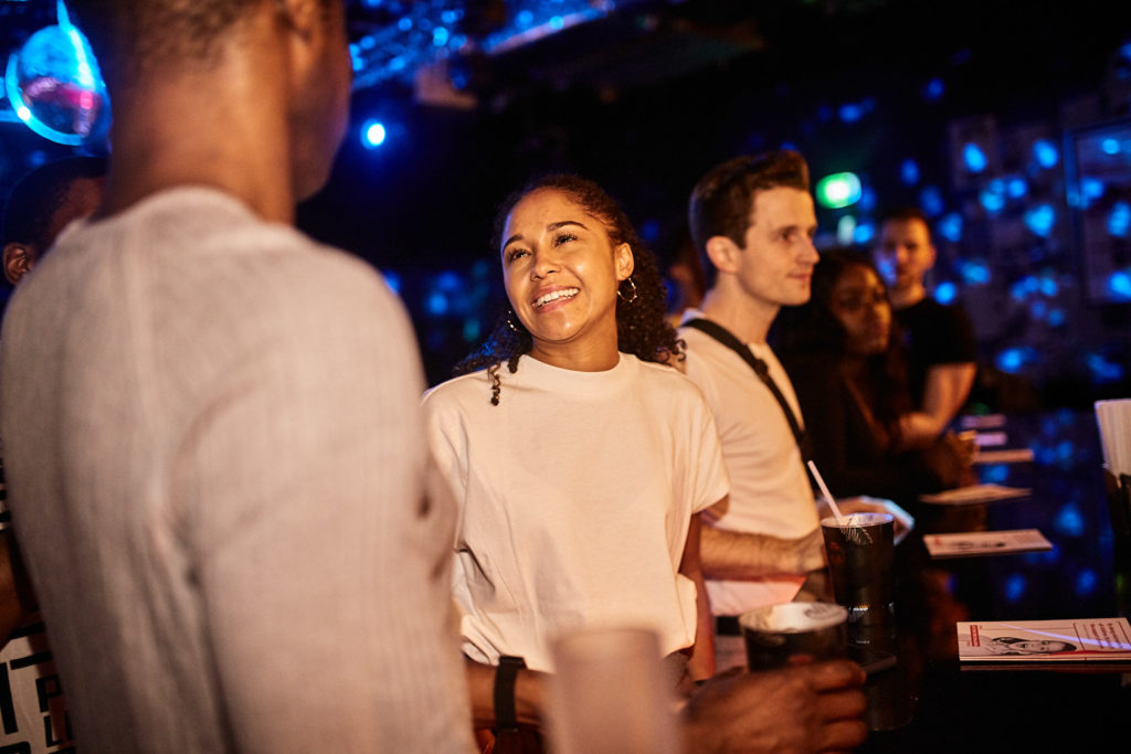 Guests smiling together under blue club lights