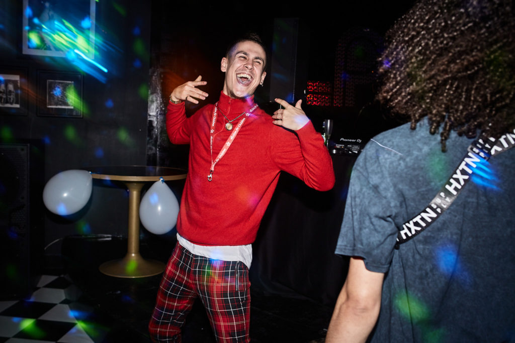 Guest in a red jumper dancing with his arms out