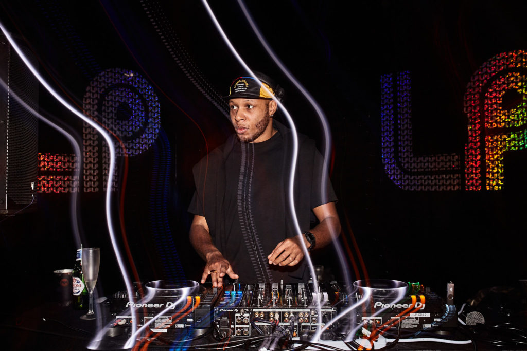DJ mixing on the decks among trails of light