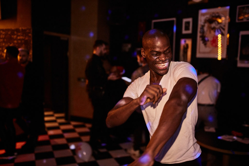 Guest in a white T-shirt dancing on the chequered dance floor