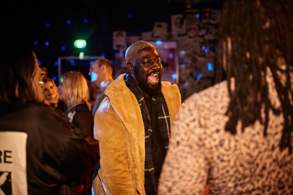 Guest in a yellow jacket laughing with friends