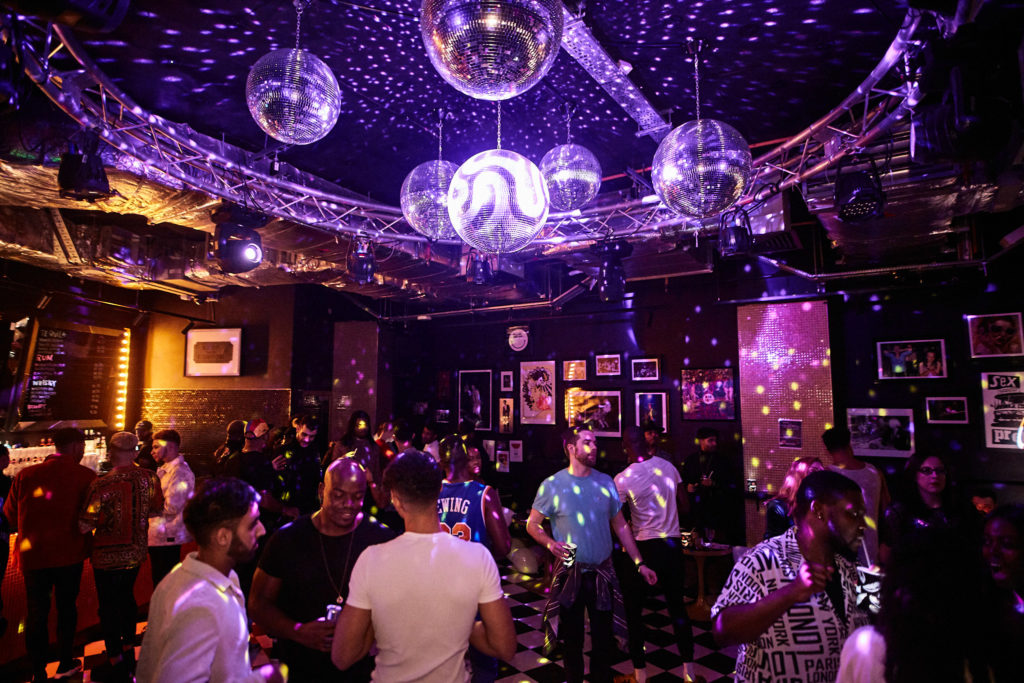 Dance floor filled with guests under mirror balls at The Curtain Club