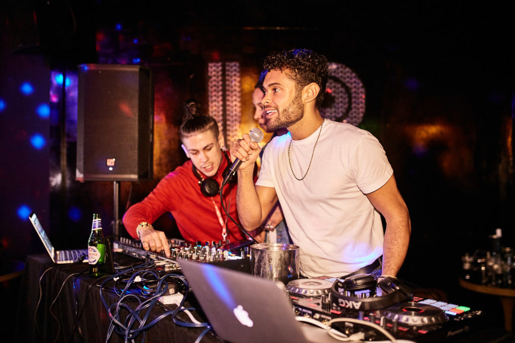 Two DJs behind the decks at the charity club night