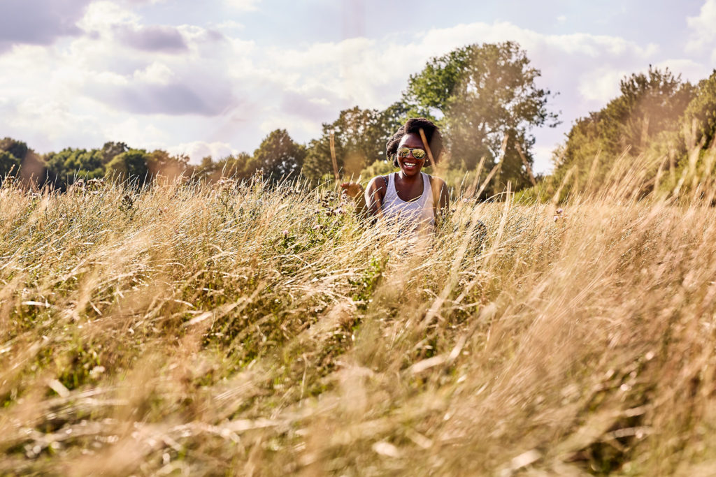 Woman walking through tall golden grass on Hampstead Heath