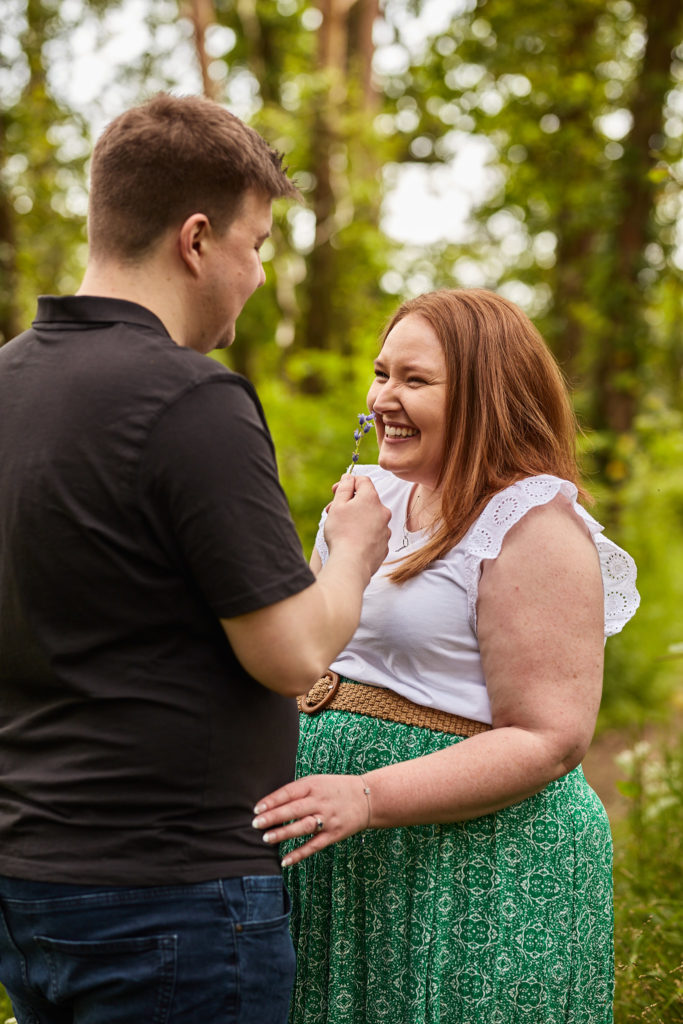 Woman laughing with her fiancé in the woods