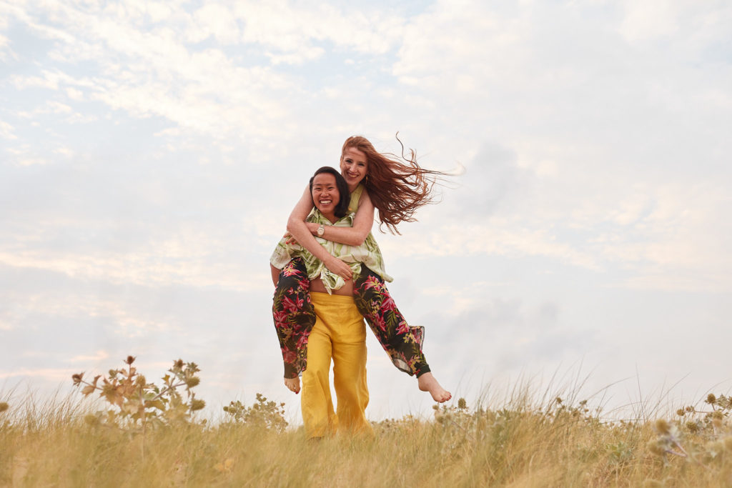 Woman carrying her fiancée on her back through the dunes