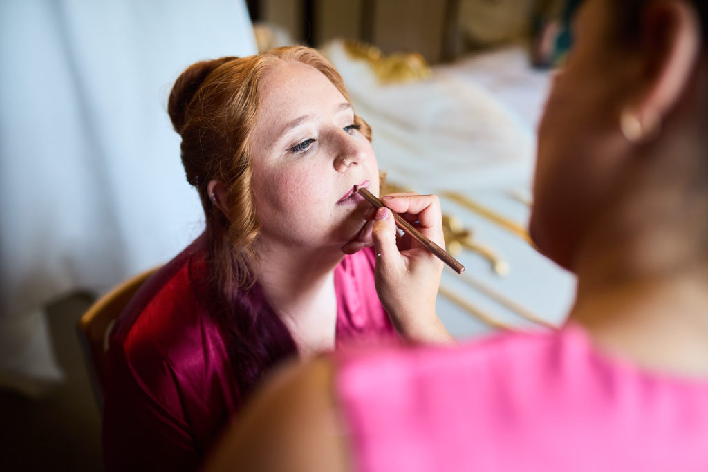 Close-up of the bride having her lipstick applied
