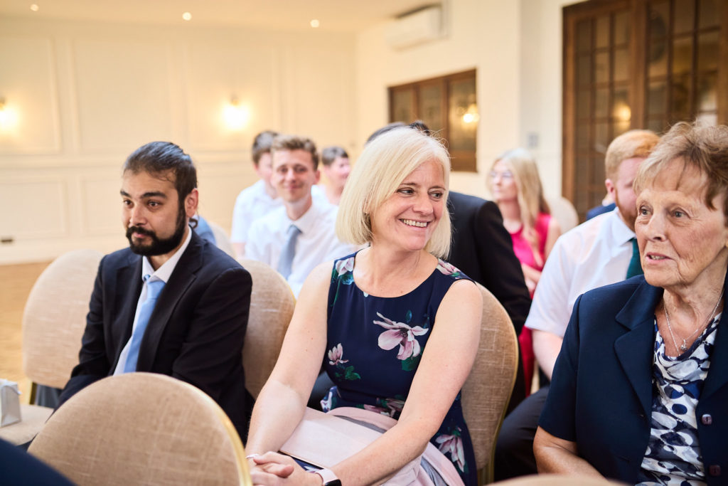 Wedding guests seated and smiling before the ceremony