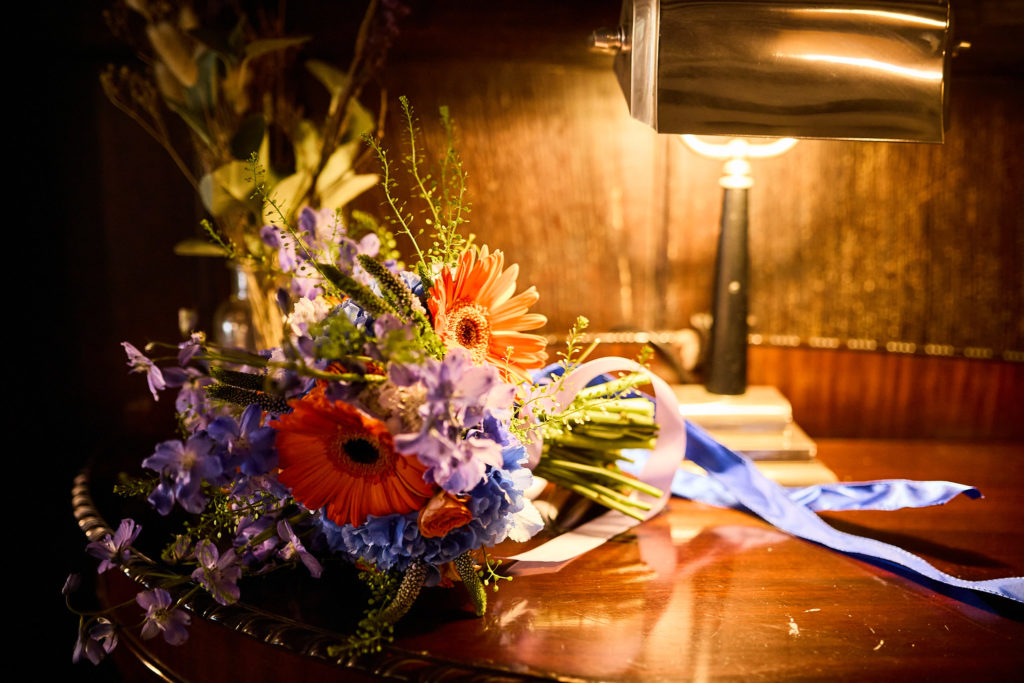 Bridal bouquet on a table under a lamp in a wood-panelled room