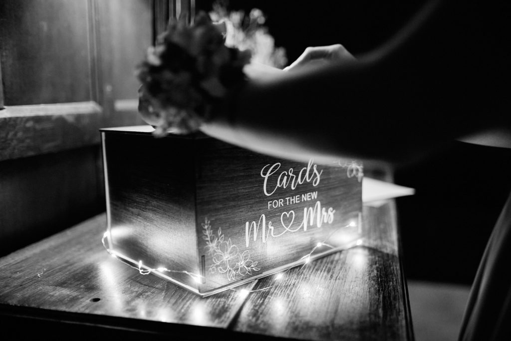 Black and white photo of a "Cards for the new Mr & Mrs" box lit with fairy lights