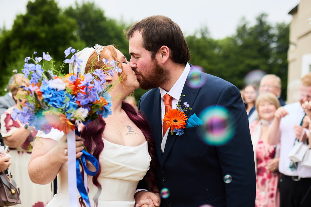 Close-up of the bride and groom kissing among bubbles
