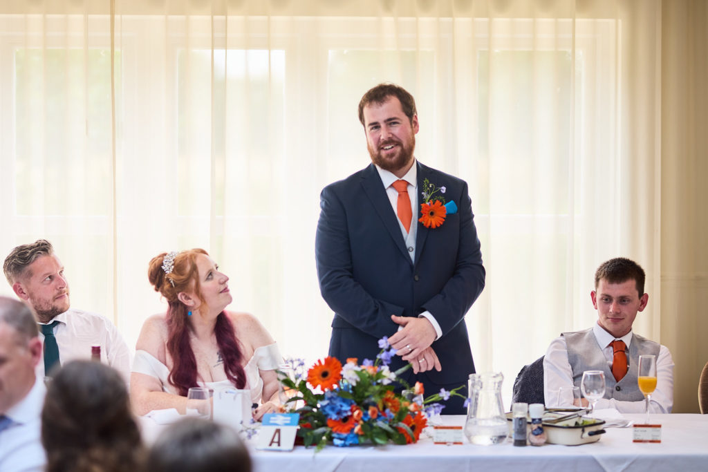 Groom standing to give his wedding speech