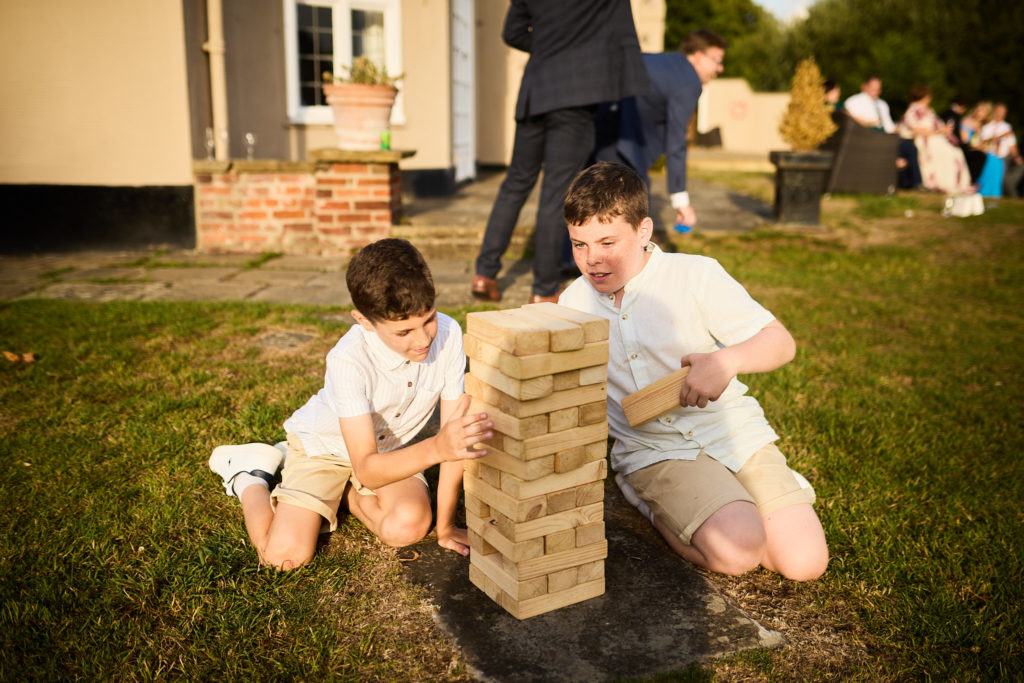 Two boys playing giant Jenga on the lawn