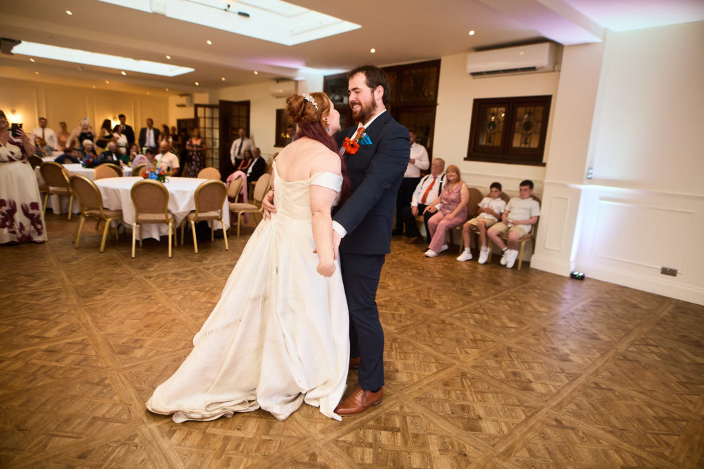 Bride and groom's first dance watched by their guests