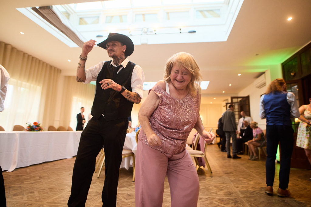 Man in a cowboy hat dancing with a woman in a pink dress