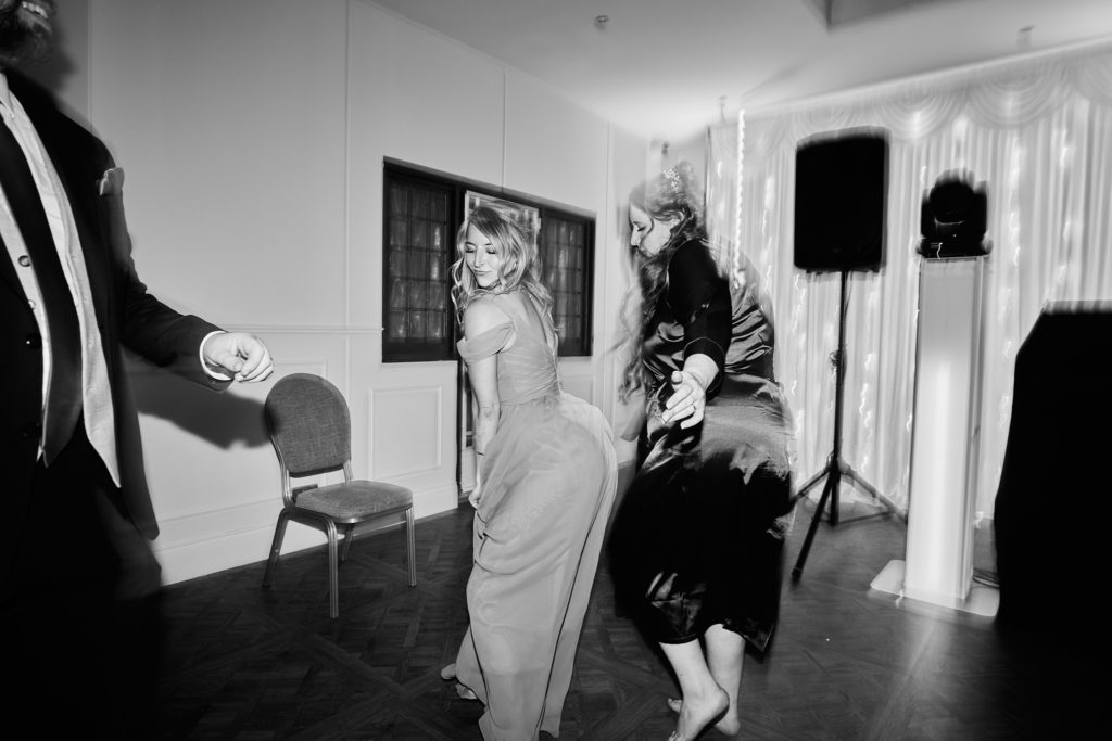 Black and white photo of guests dancing beside the speakers