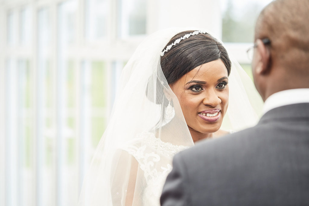 Bride in her veil looking at the groom during the wedding ceremony