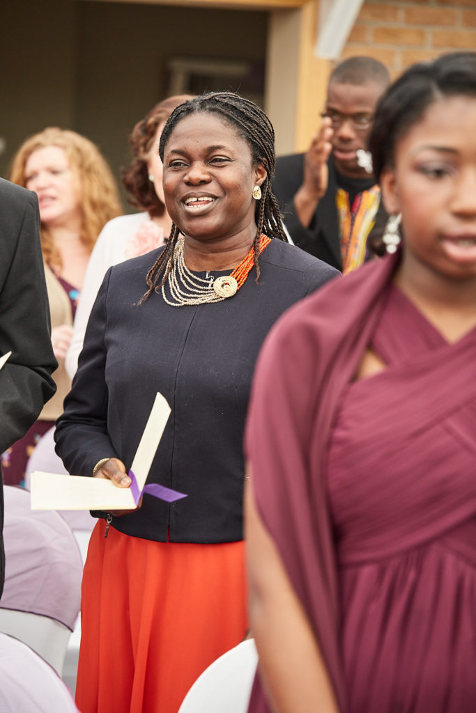 Wedding guest smiling as she takes her seat for the ceremony