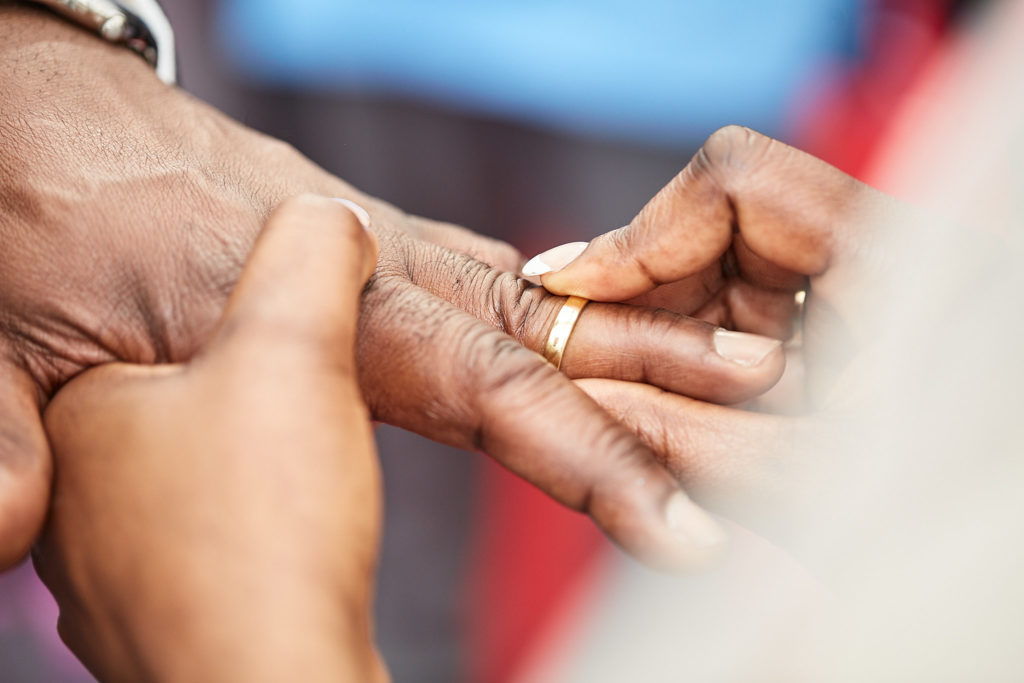 Close-up of the wedding ring being placed on a finger during the ceremony