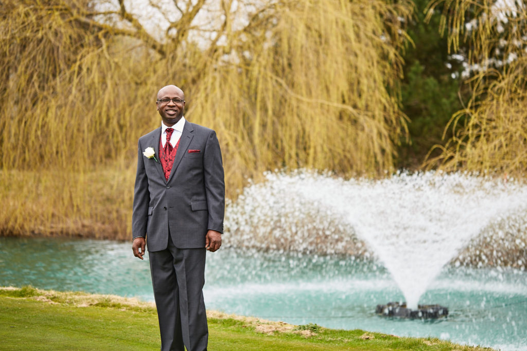 Groom standing in front of the fountain at Essex Golf Club