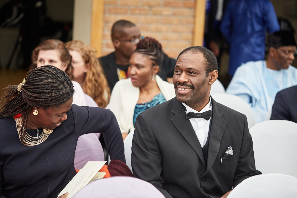 Wedding guest in a bow tie smiling as he waits for the ceremony