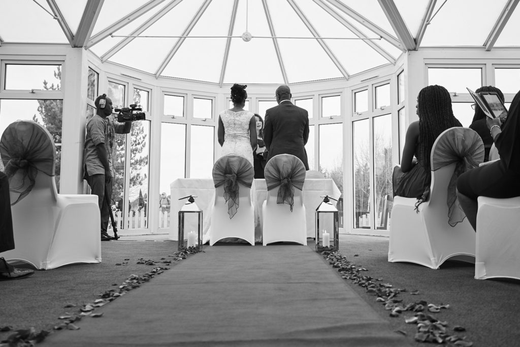 Black and white photo of the wedding ceremony in the conservatory at Essex Golf Club