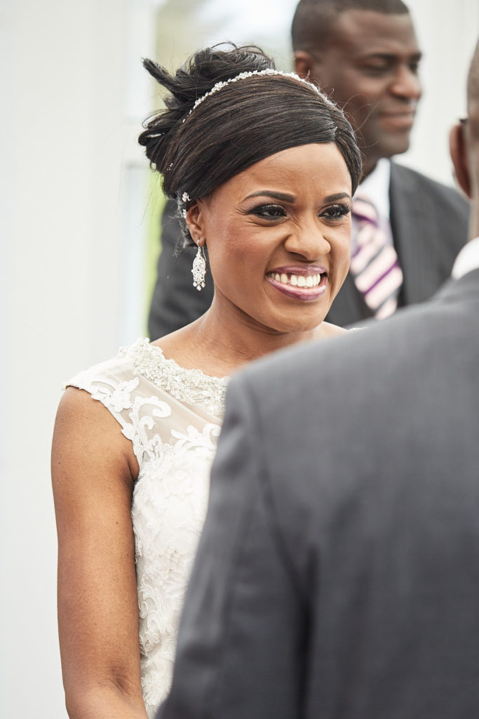Bride laughing as she faces the groom during their vows