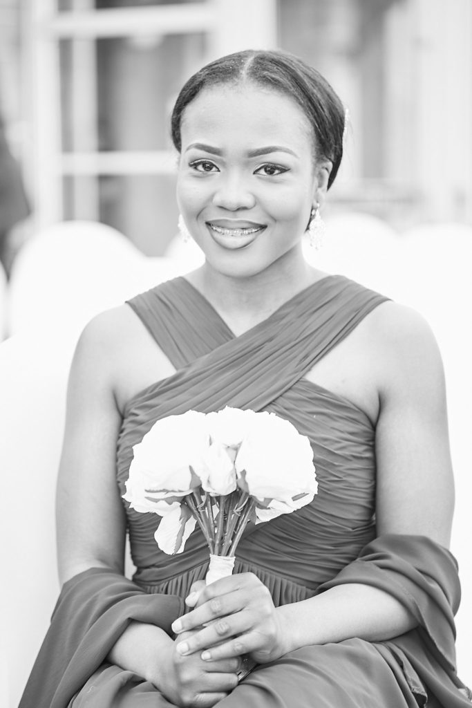 Black and white portrait of a bridesmaid holding her bouquet