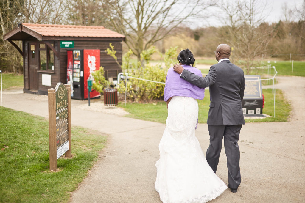 Bride and groom walking away along a path at Essex Golf Club