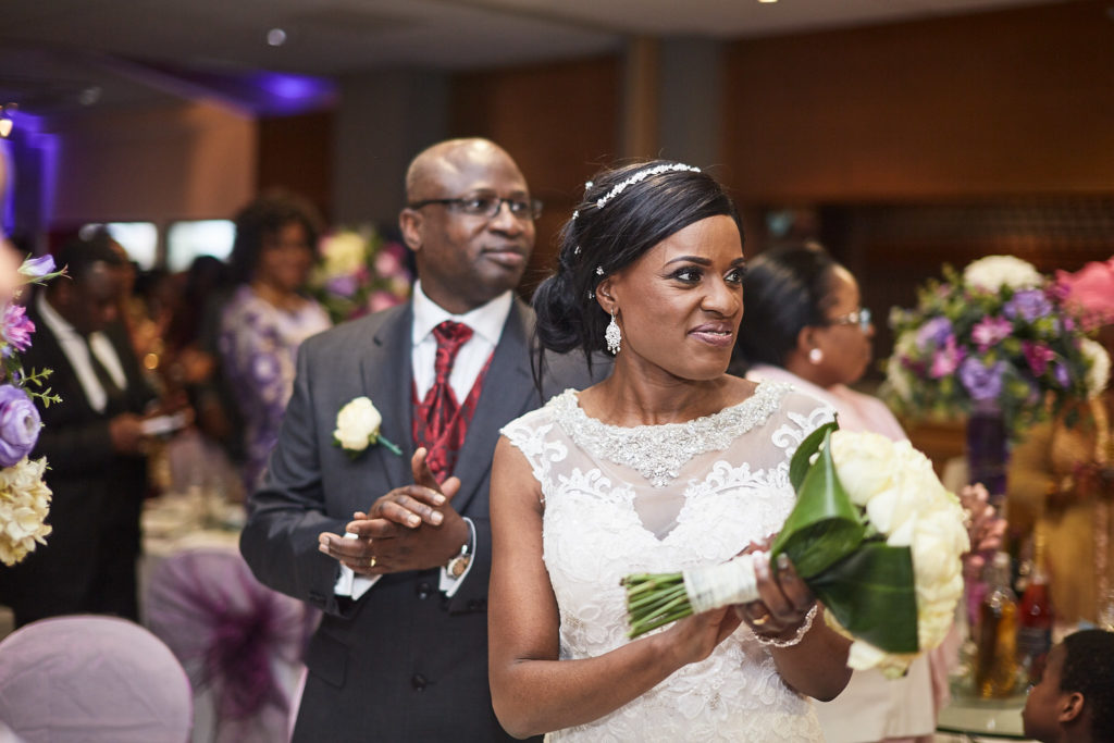 Bride and groom making their entrance to the reception as guests applaud