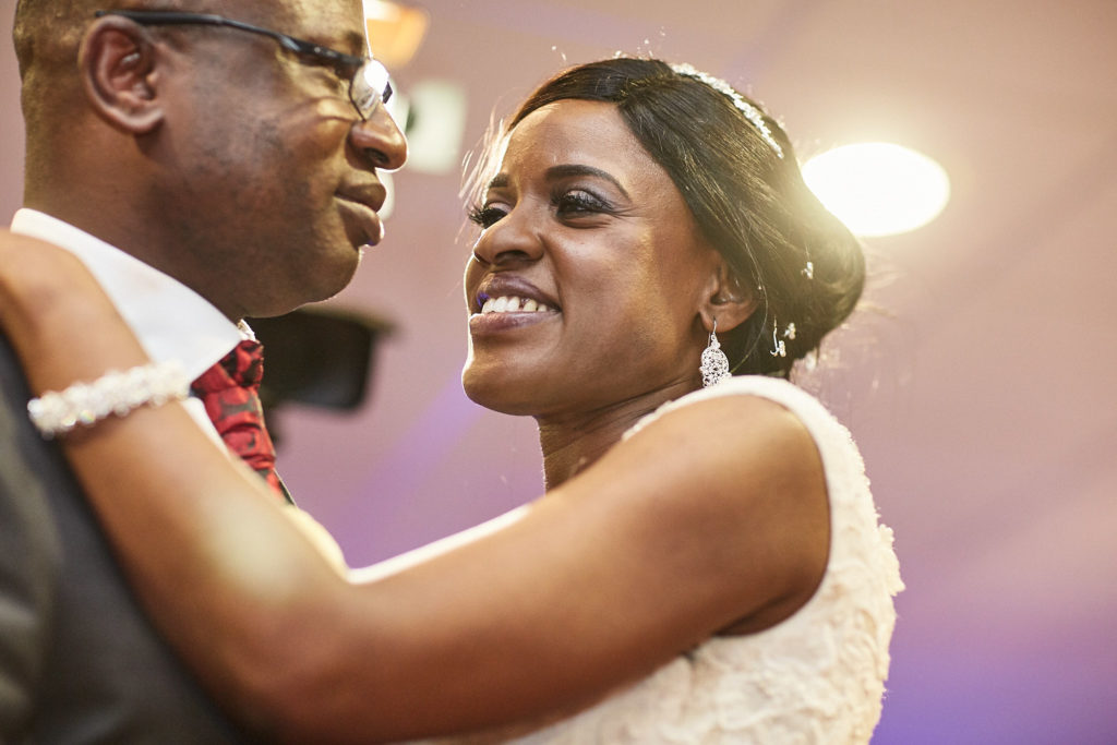 Bride and groom smiling at each other during their first dance
