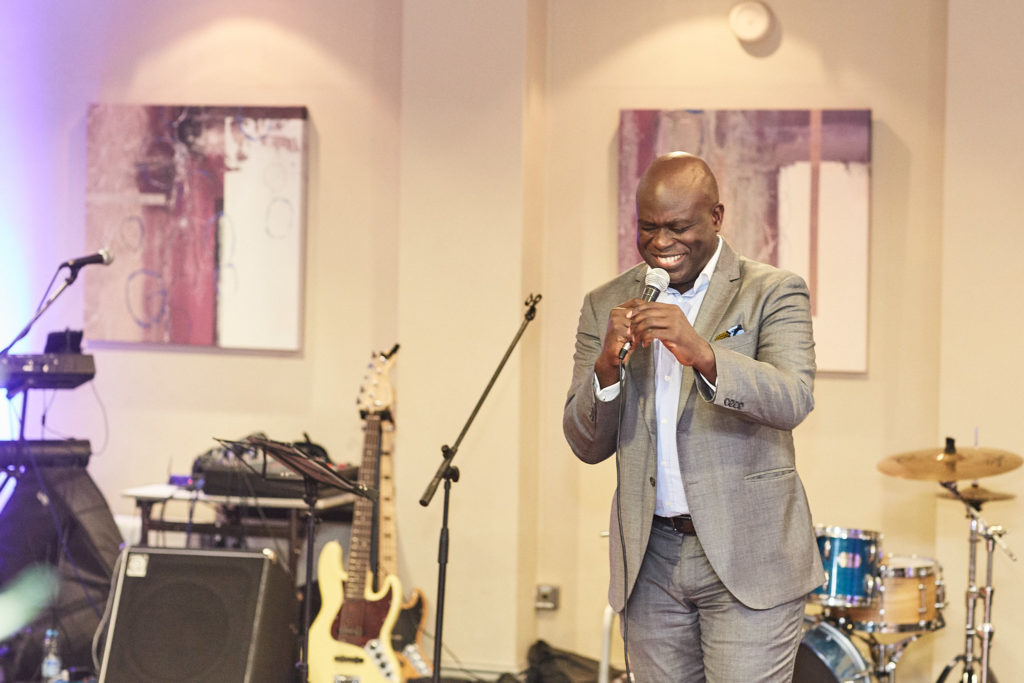 Guest speaking with a microphone in front of the band's instruments
