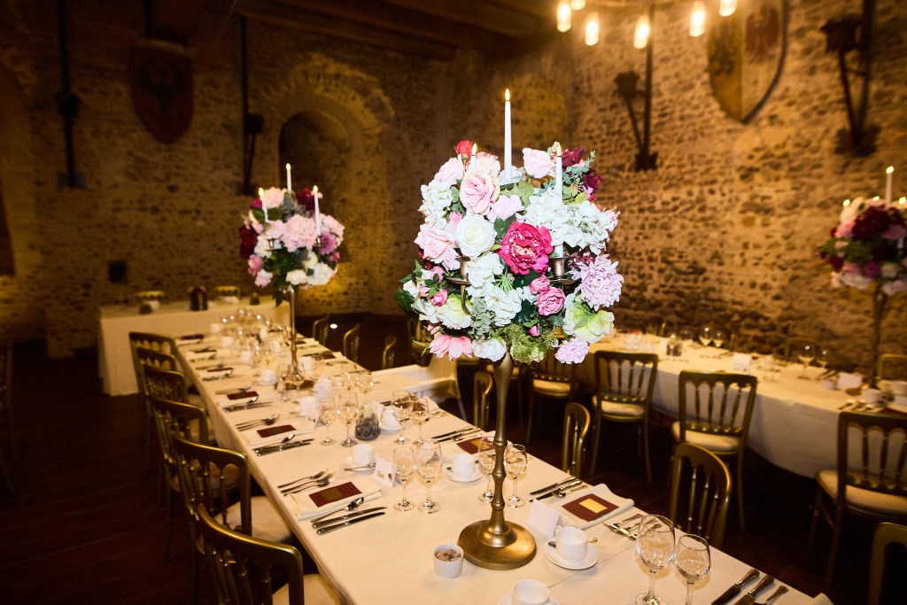 Banquet table set with candelabra flower centrepieces in the hall at Hedingham Castle