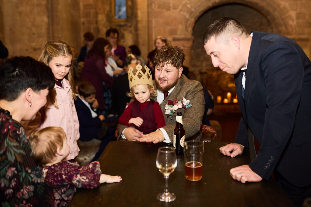 Wedding guests and children gathered round a table in the castle