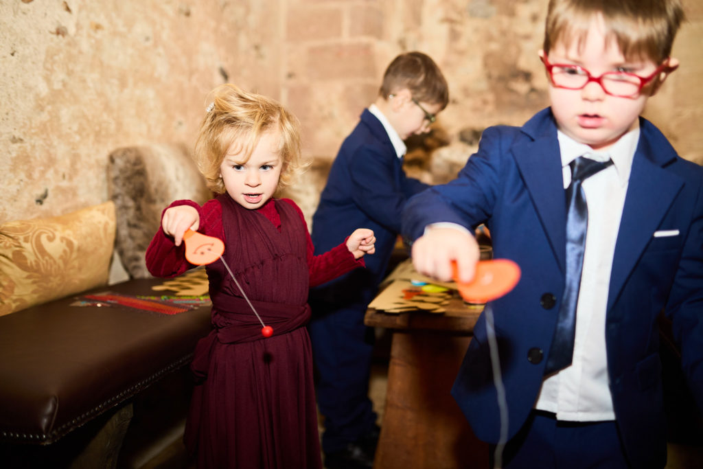 Children playing at the reception, a boy in glasses and a navy suit