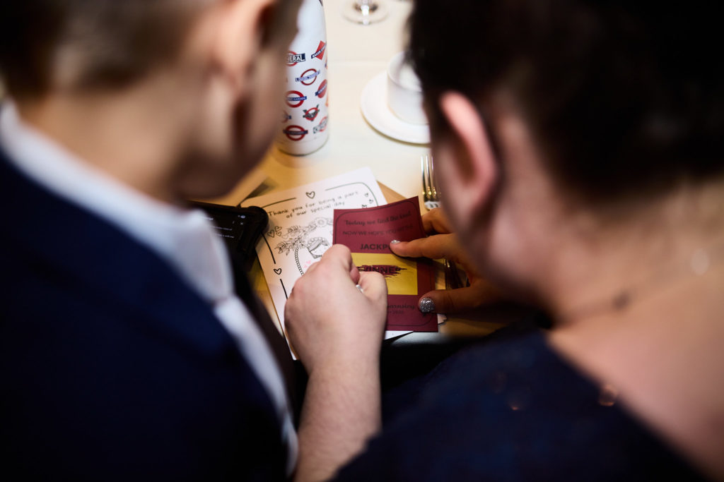 Two wedding guests looking at a card together