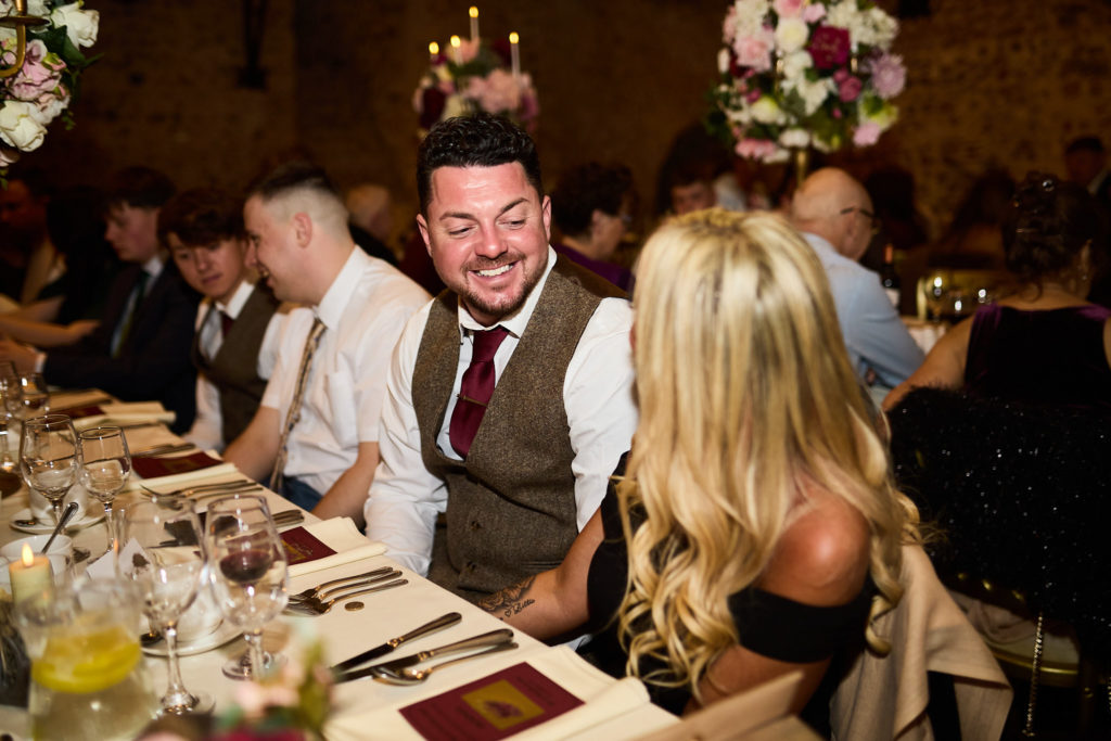 Wedding guest in a waistcoat smiling at the table