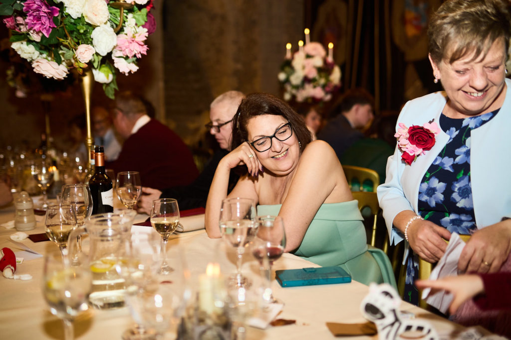 Wedding guests smiling at the table during the wedding breakfast