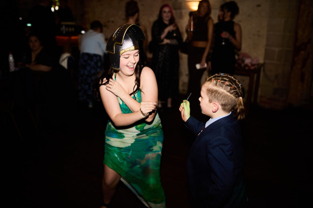 Guest in a green dress dancing with a young boy