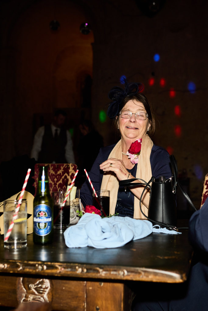 Older guest laughing at a table of drinks