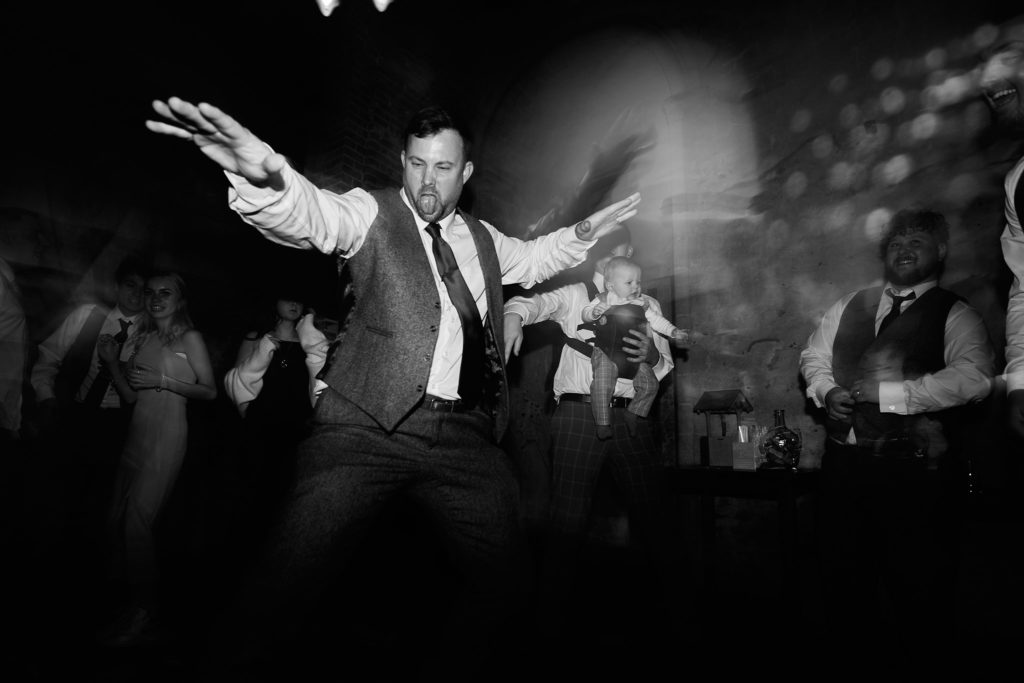 Black and white photo of a man dancing with his arms outstretched