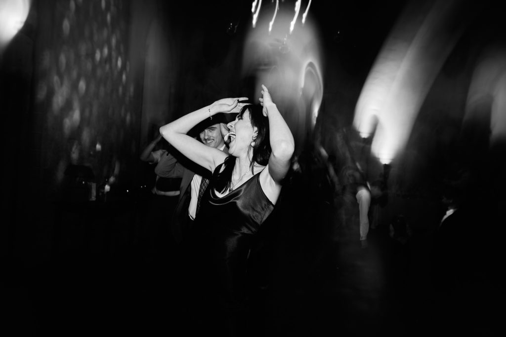 Black and white photo of a guest dancing among light trails