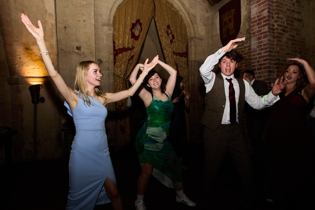 Wedding guests dancing with their arms in the air