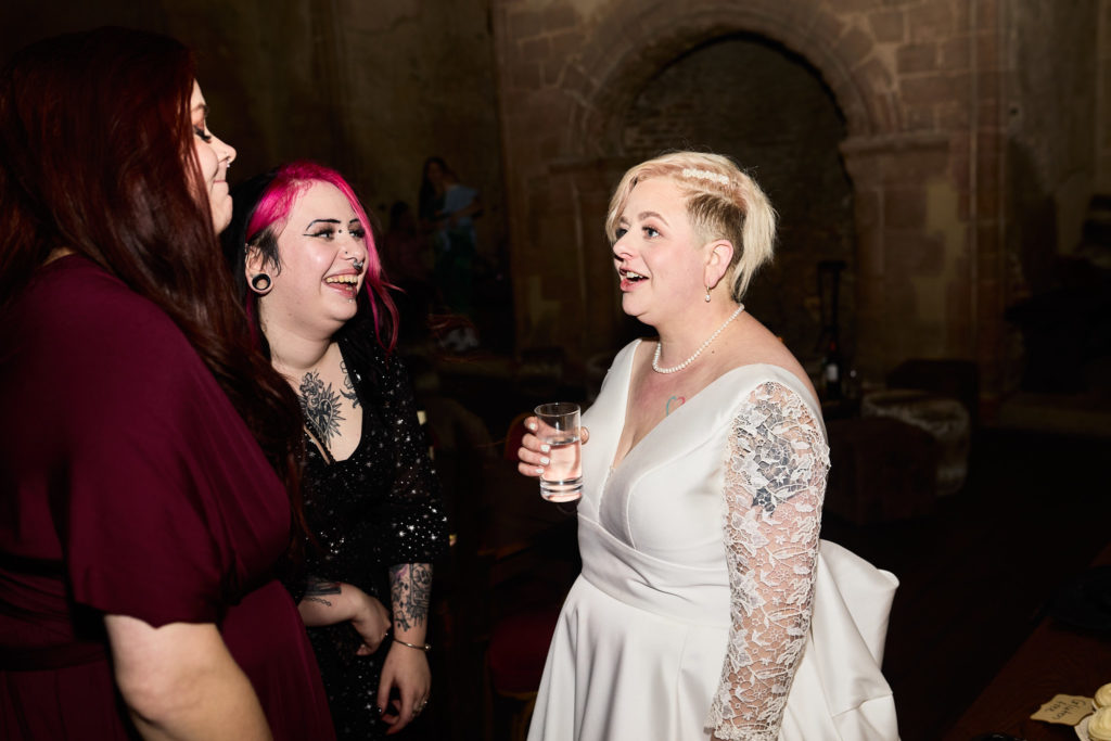 Bride laughing with two guests at the evening reception
